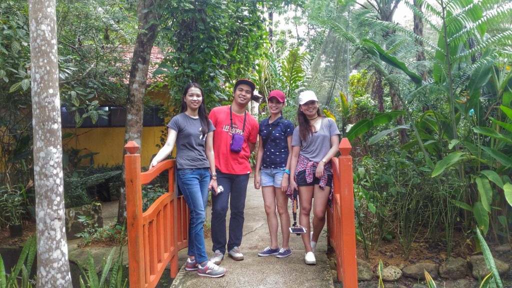 a group picture with my friends on a bridge inside the butterfly garden