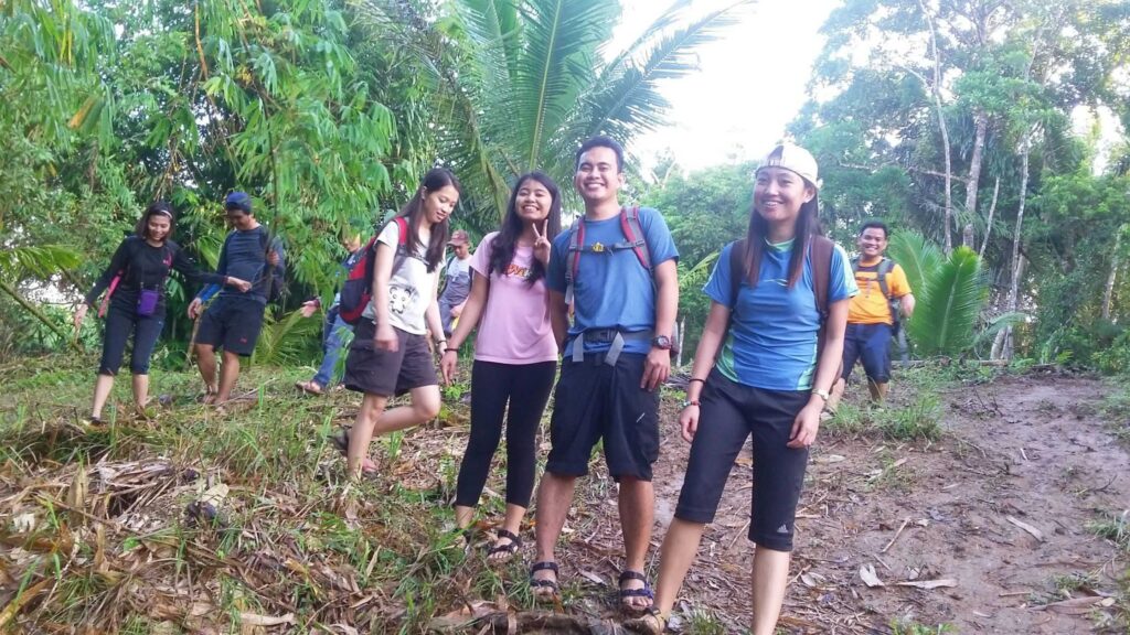 Picture with friends while going down a muddy trail to hulugan falls