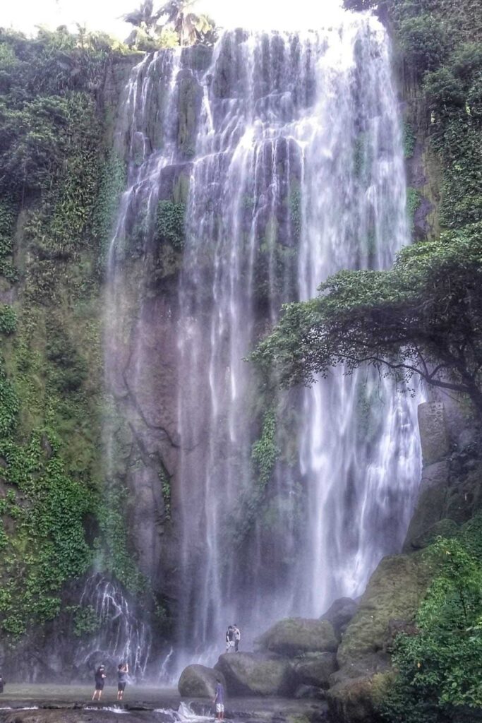 A picture of Hulugan Falls with people on the foot of it.