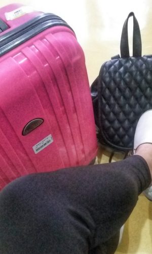 a pink luggage, black back pack